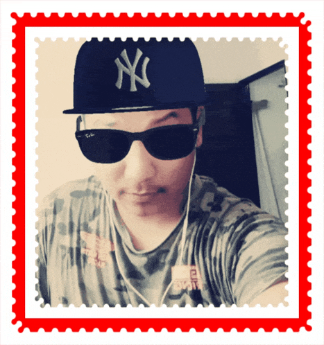a man wearing sunglasses and a ny hat takes a selfie