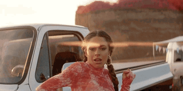 a woman is standing next to a white truck .