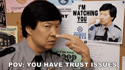 a man points at a poster that says " i 'm watching you "
