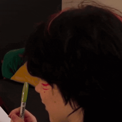 a woman with red and black hair has the word what on her face .