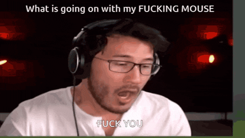 a man wearing headphones and glasses says " what is going on with my fucking mouse fuck you "