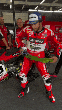 a man wearing a red and white lenovo monster energy racing suit