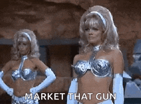 two women in bikinis and gloves are standing next to each other .