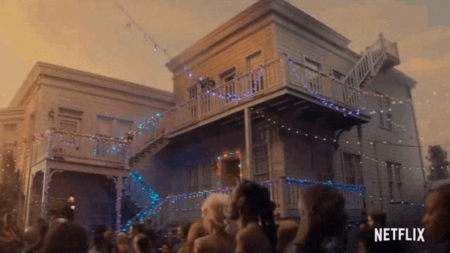 a crowd of people are gathered in front of a house with netflix written on the bottom right