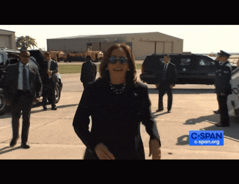 a woman wearing sunglasses walks in front of a sign that says c span