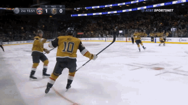 a hockey player with the number 10 on his jersey stands on the ice