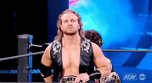 a man in a wrestling ring with the aew logo on the bottom right