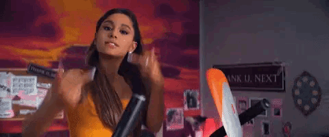 ariana grande is making a funny face while standing in front of an exercise bike .