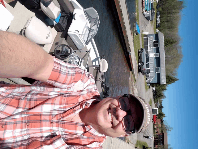 a man wearing a hat that says ' iowa ' on it smiles while sitting on a boat