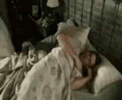 a man is laying in a bed with a pillow and a blanket .
