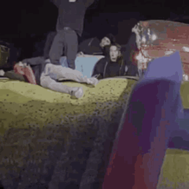 a group of people are laying on top of a pile of hay