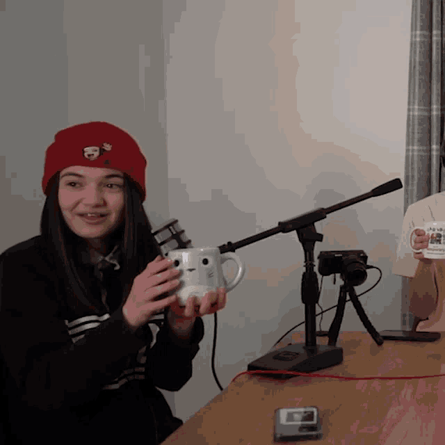a girl in a red hat is holding a mug that says i 'm a chicken