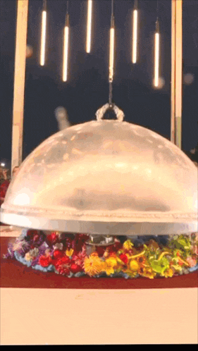 a dome with flowers underneath it is being lifted by a crane