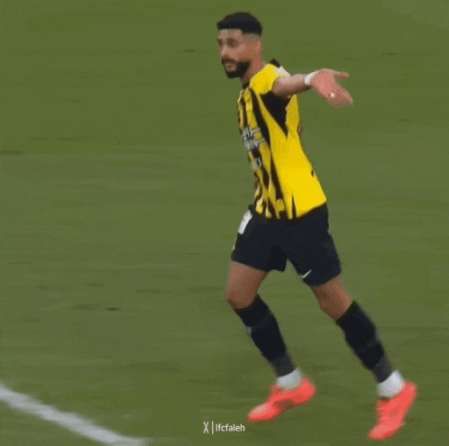 a soccer player wearing a yellow and black jersey that says ' fc falleh ' on the front