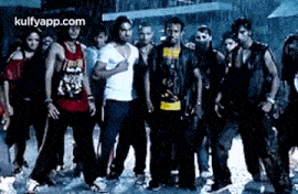 a group of young men are standing next to each other on a street in the rain .