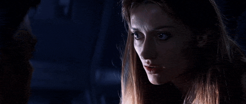 a man and a woman are looking at each other in the dark .