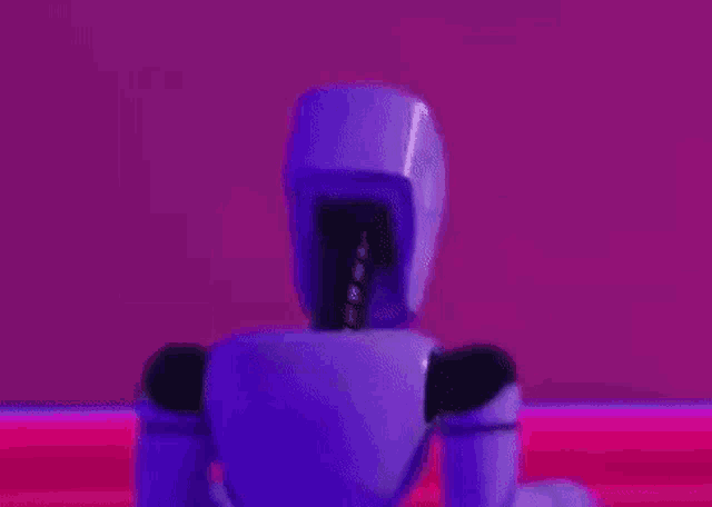 a purple robot is standing in front of a pink background in a room .