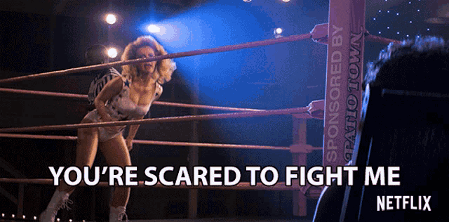 a woman in a wrestling ring with the words " you 're scared to fight me " on the bottom