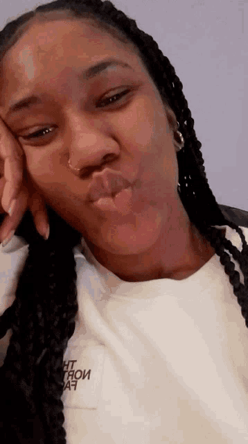 a woman wearing a white shirt that says " the north face " on it