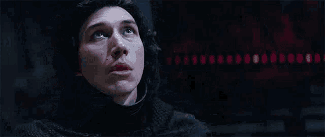 two men are standing next to each other in a dark room in a star wars movie .