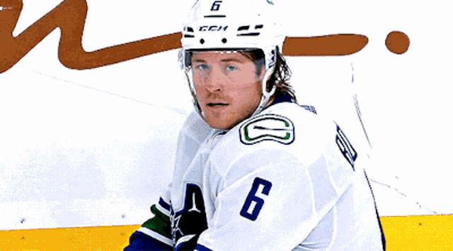 a hockey player wearing a helmet with the number 6 on it