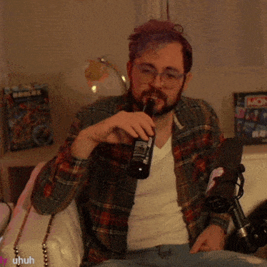 a man in a plaid shirt is drinking from a bottle with a monopoly board in the background
