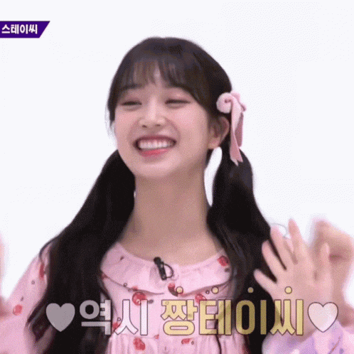 a girl in a pink dress with pigtails and a bow in her hair