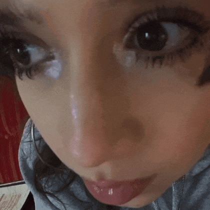 a close up of a woman 's face with a gray hoodie on