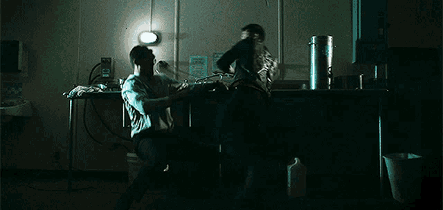 a man in a dark room with a sign on the wall that says ' emergency '