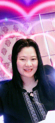 a woman is smiling in front of a wall with a heart on it