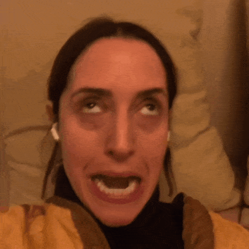 a woman is sticking her tongue out and wearing ear buds
