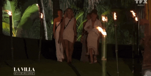 a group of women are walking through a forest with a sign that says la villa