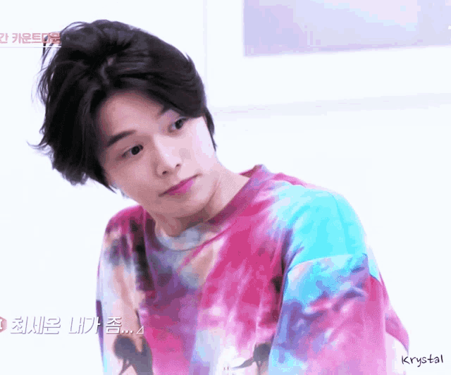 a young man wearing a tie dye shirt with krystal written on the bottom right