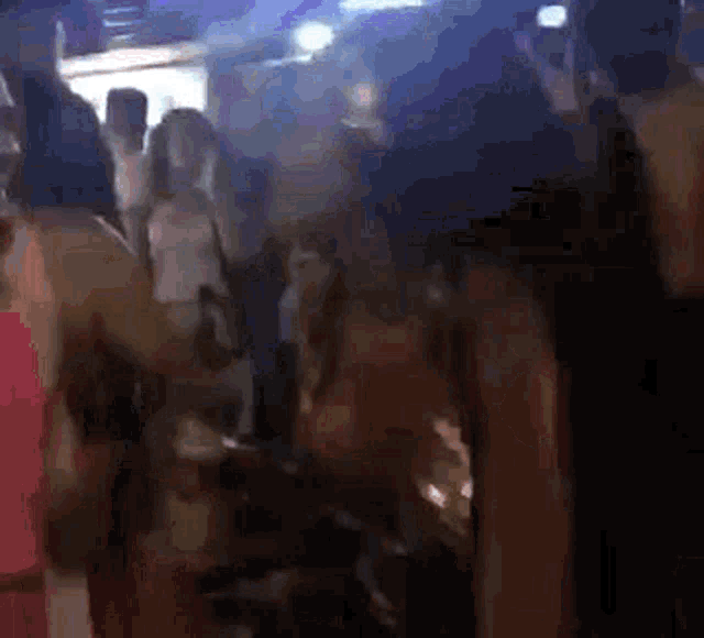 a blurry picture of a crowd of people dancing in a club .