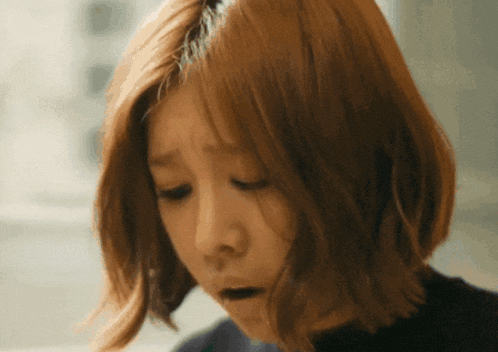 a close up of a woman 's face with a sad look on her face