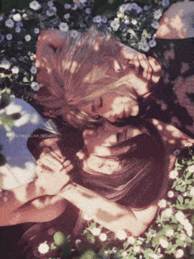 two women laying on top of each other in a field of flowers with the words " patreon " on the bottom