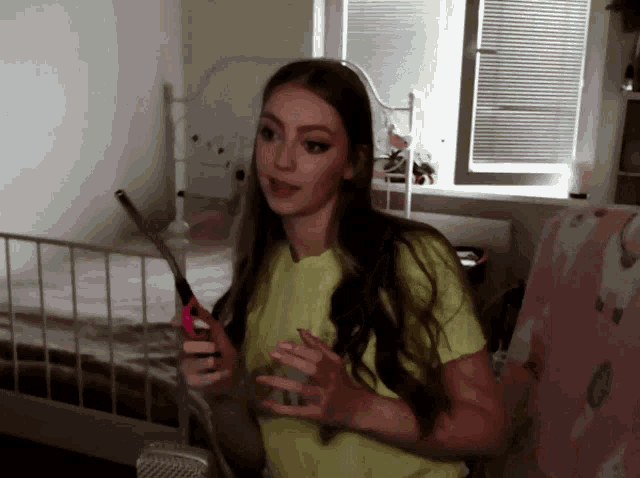 a woman holding a pair of scissors in front of a bed