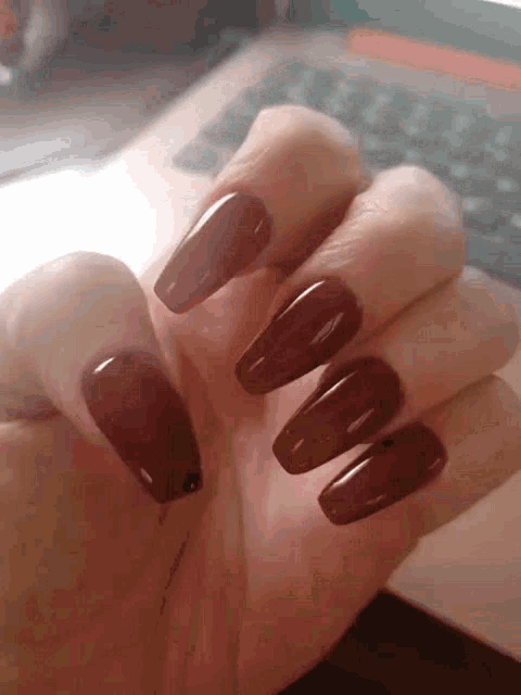 a close up of a woman 's hand with long nails