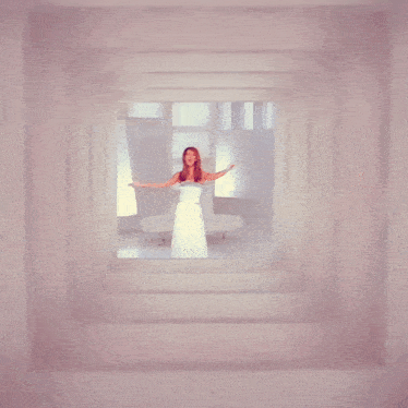 a woman in a white dress with her arms outstretched
