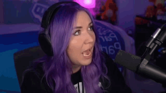 a woman with purple hair is talking into a microphone and saying `` i 'm gonna fight everybody ''