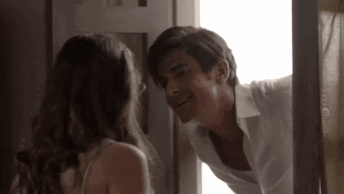 a man and woman are looking at each other in a doorway