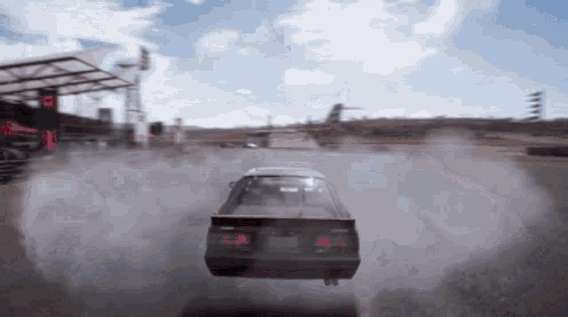a car is driving down a track with smoke coming out of the back