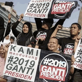 a group of people hold up signs that say kami mendukung # 2019 ganti presiden
