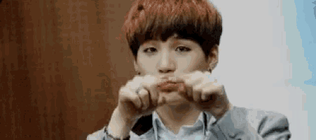 a man with red hair is making a funny face with his hands .