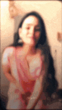a blurry picture of a woman in a pink dress with long hair