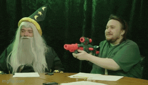 a man in a wizard costume holds a toy gun next to a man in a green shirt