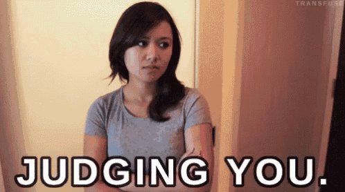 a woman with her arms crossed and the words judging you behind her