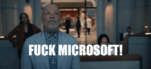 a man in a suit says fuck microsoft in front of a crowd