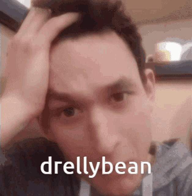 a close up of a man 's face with the name drillybean written on the bottom