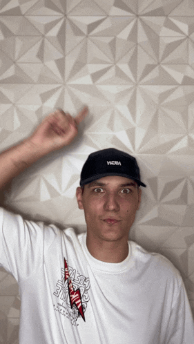 a man wearing a white shirt and a black hat with the word hoh on it